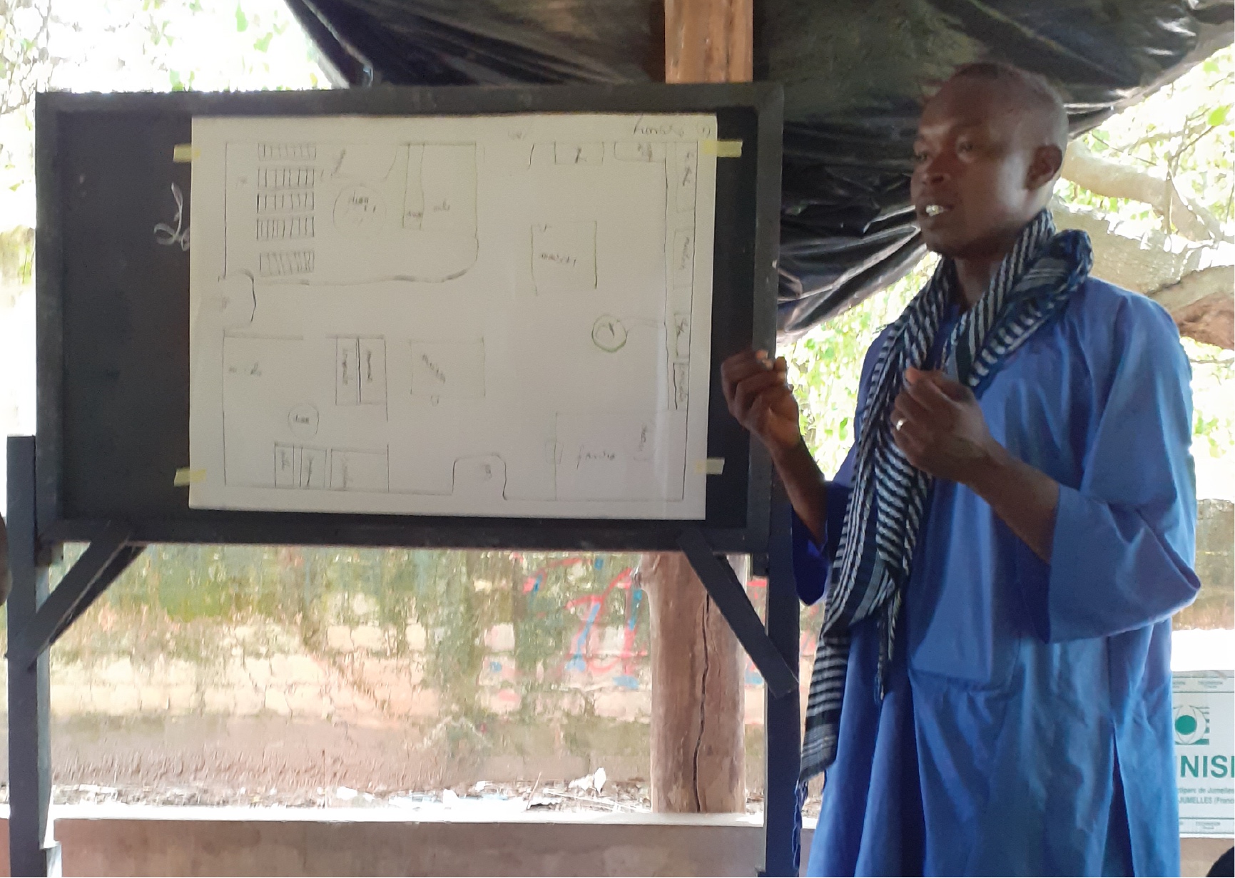 A Trees for the Future staff member giving training sessions to farmers to strategically map out their crops before planting.